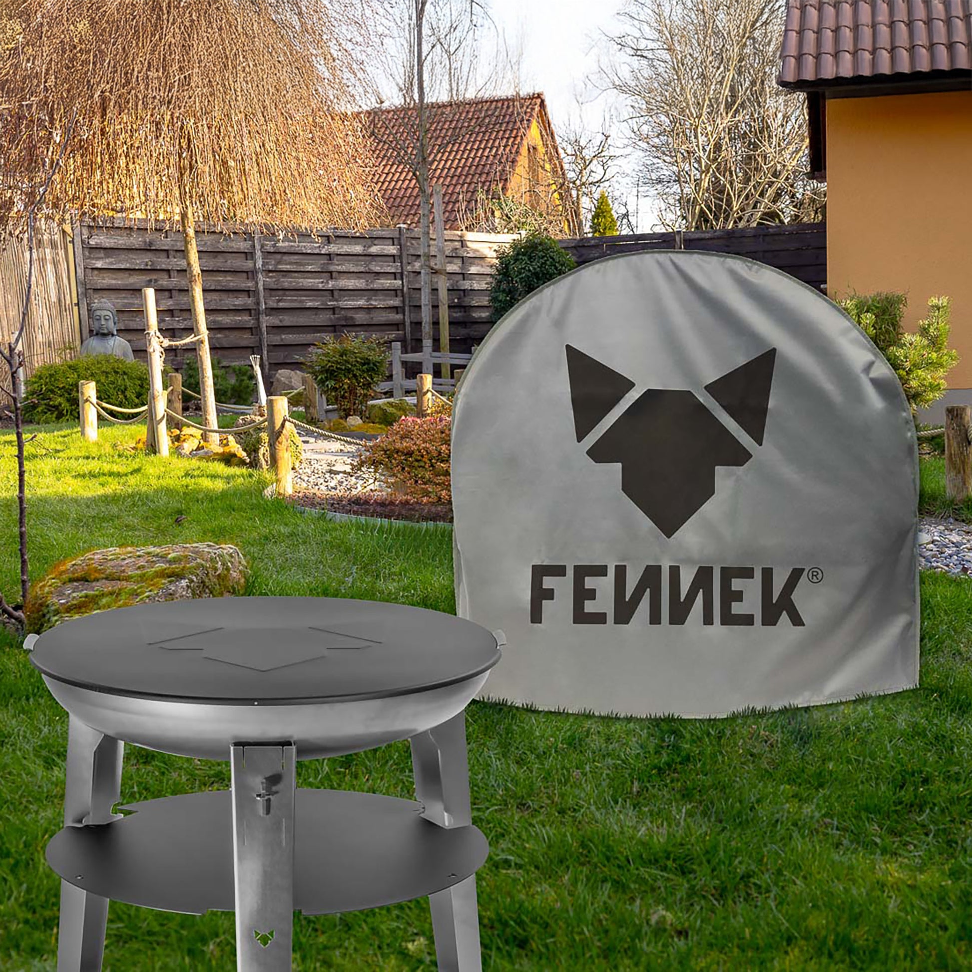 Die FENNEK Feuerschale Allround steht aufgebaut in einem Garten. Dahinter befindet sich eine weitere Feuerschale, welche mit der FENNEK Abdeckhaube abgedeckt ist.