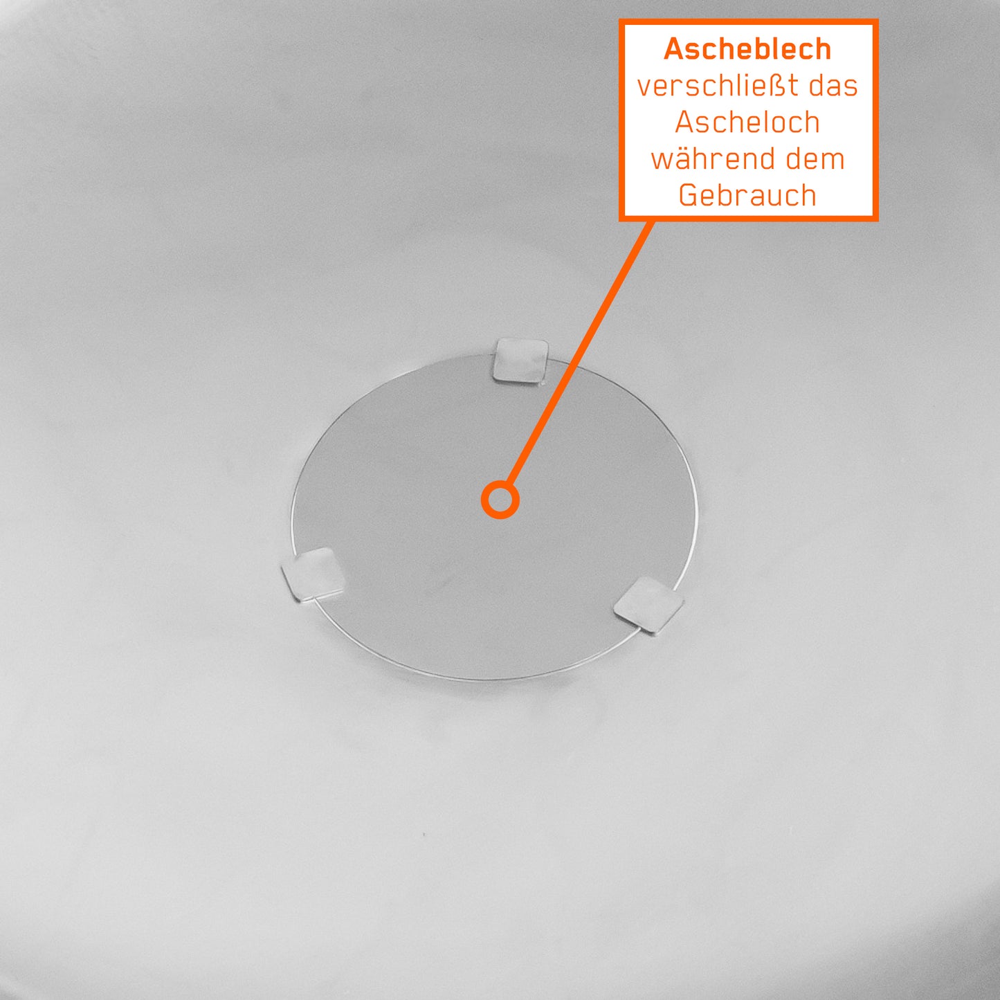 Blick in die Feuerschale mit geschlossenem Ascheloch und Infotext dazu.