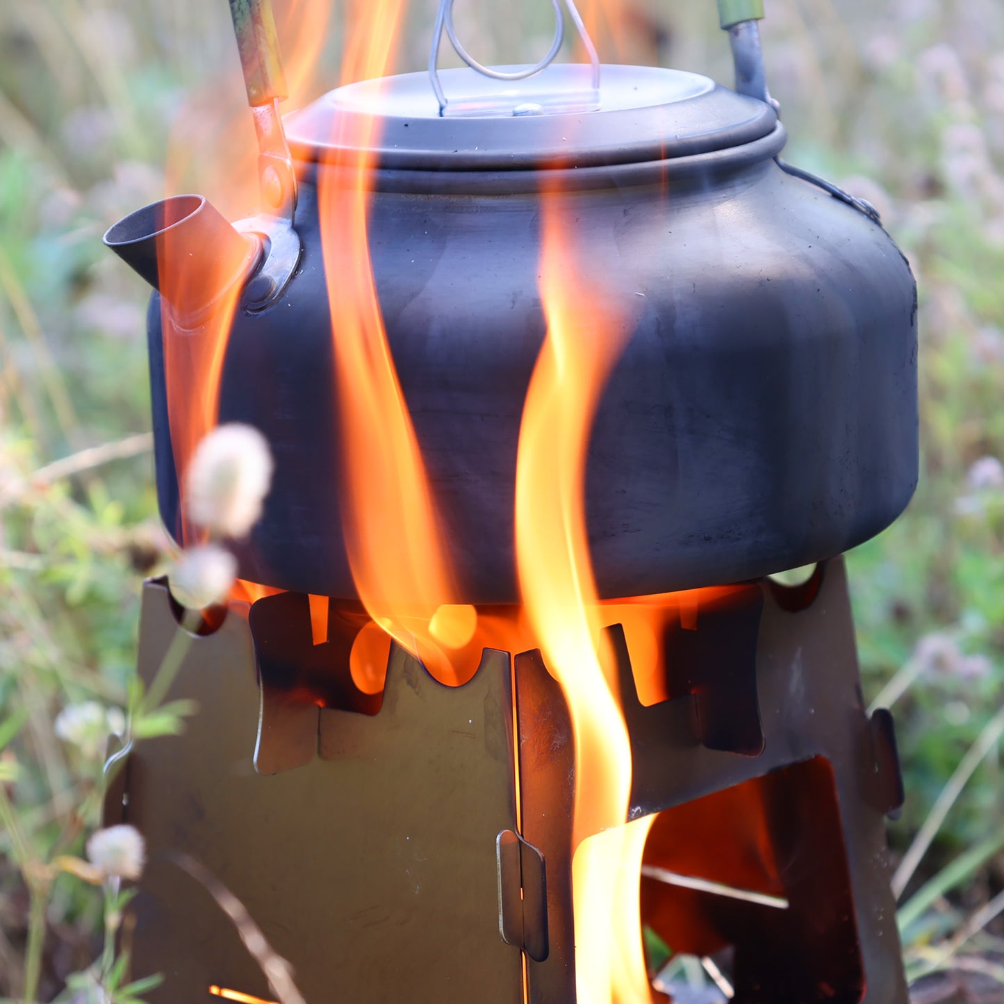Schwarzer Wasserkessel von Flammen umgeben die aus dem Hobokocher darunter nach oben steigen