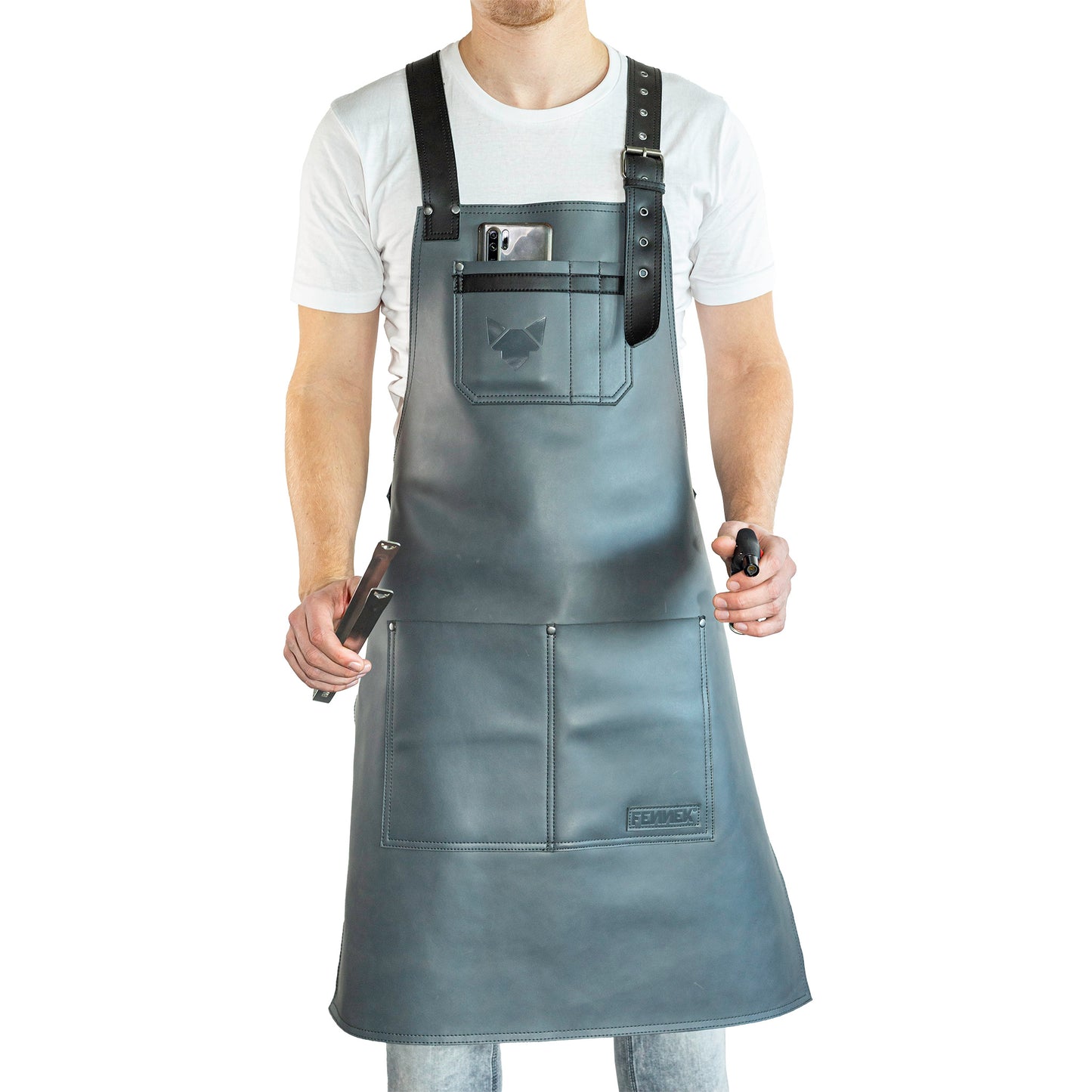 Studioaufnahme der Leder-Grillschürze getragen von einem Model das Grillzange und Feuerzeug in den Händen hält