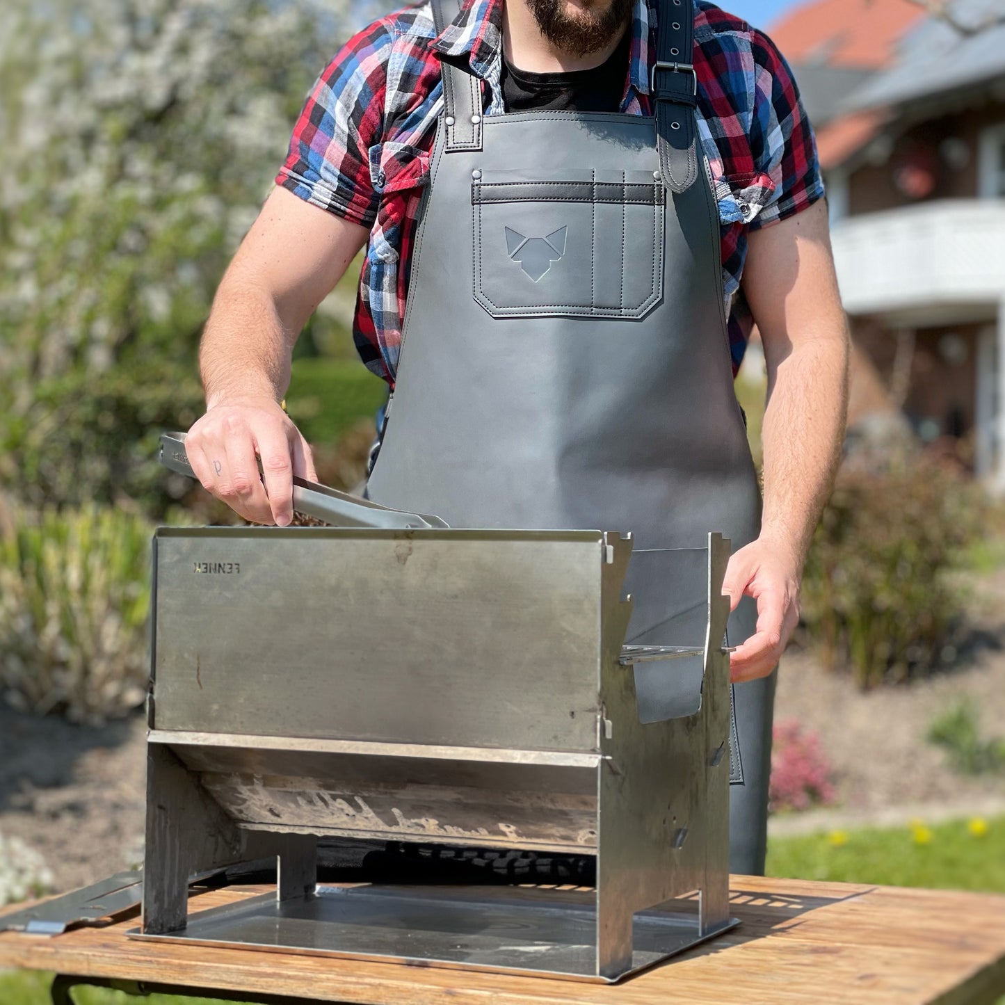 Grillschürze aus Leder, getragen im Garten beim Grillen