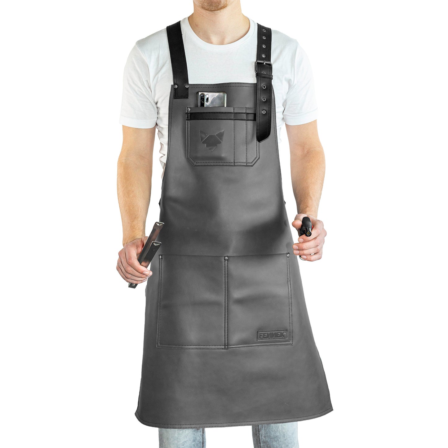 Studioaufnahme der Leder-Grillschürze getragen von einem Model das Grillzange und Feuerzeug in den Händen hält