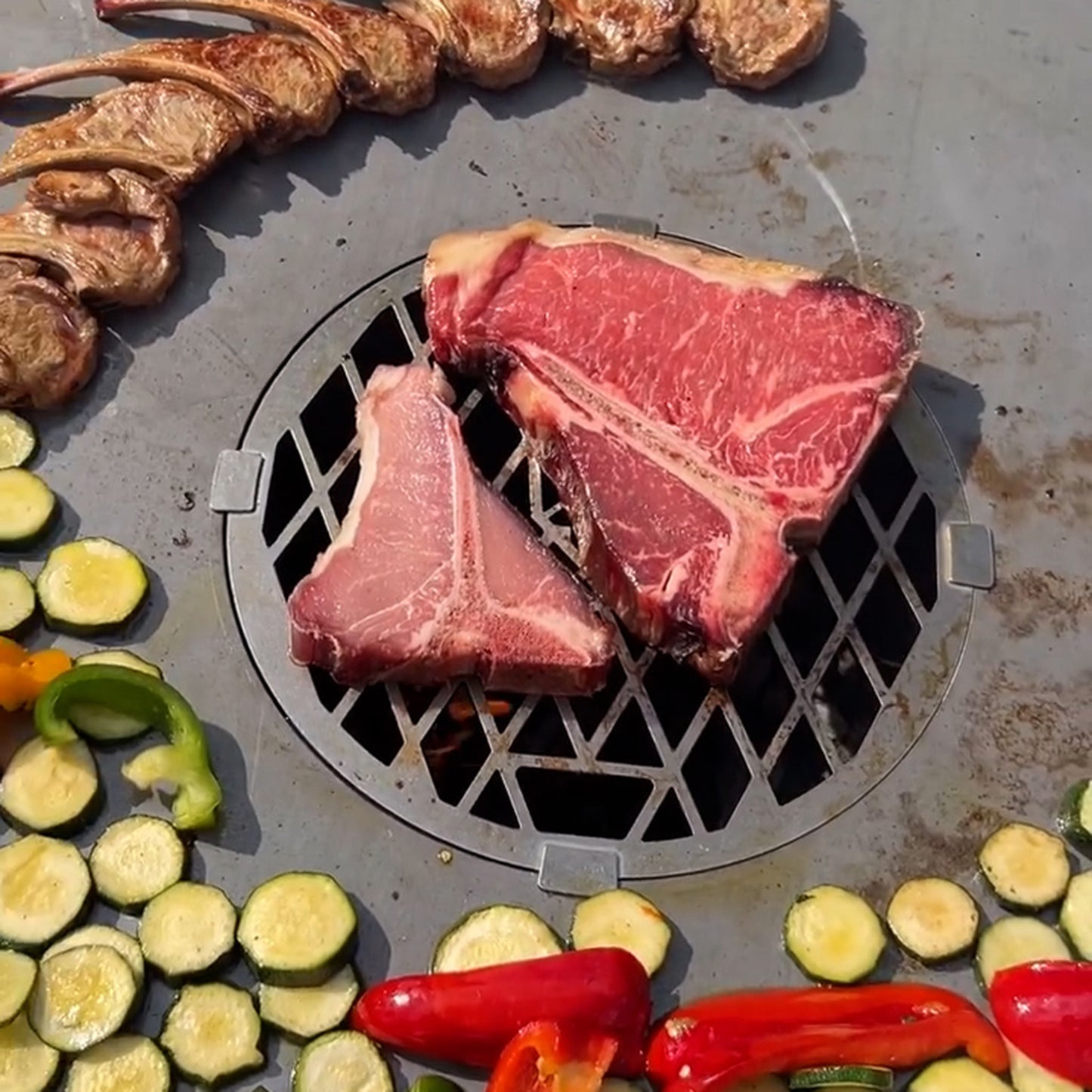 Edelstahl Grilleinsatz für die FENNEK Feuerschale Allround aus Edelstahl im Einsatz. Das saftige Steak liegt direkt auf dem Grilleinsatz, damit es direktes Feuer abbekommen kann..