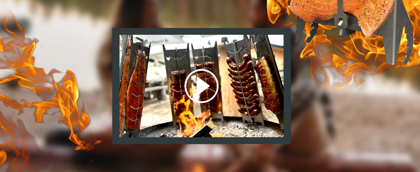 Bild zeigt einen kleinen Bildausschnitt auf welchem sechs FENNEK Flammlachshalter zu sehen sind, unter anderem mit Lachs, Würstchen und Rippchen. Links und rechts im Bild sieht man Flammen.