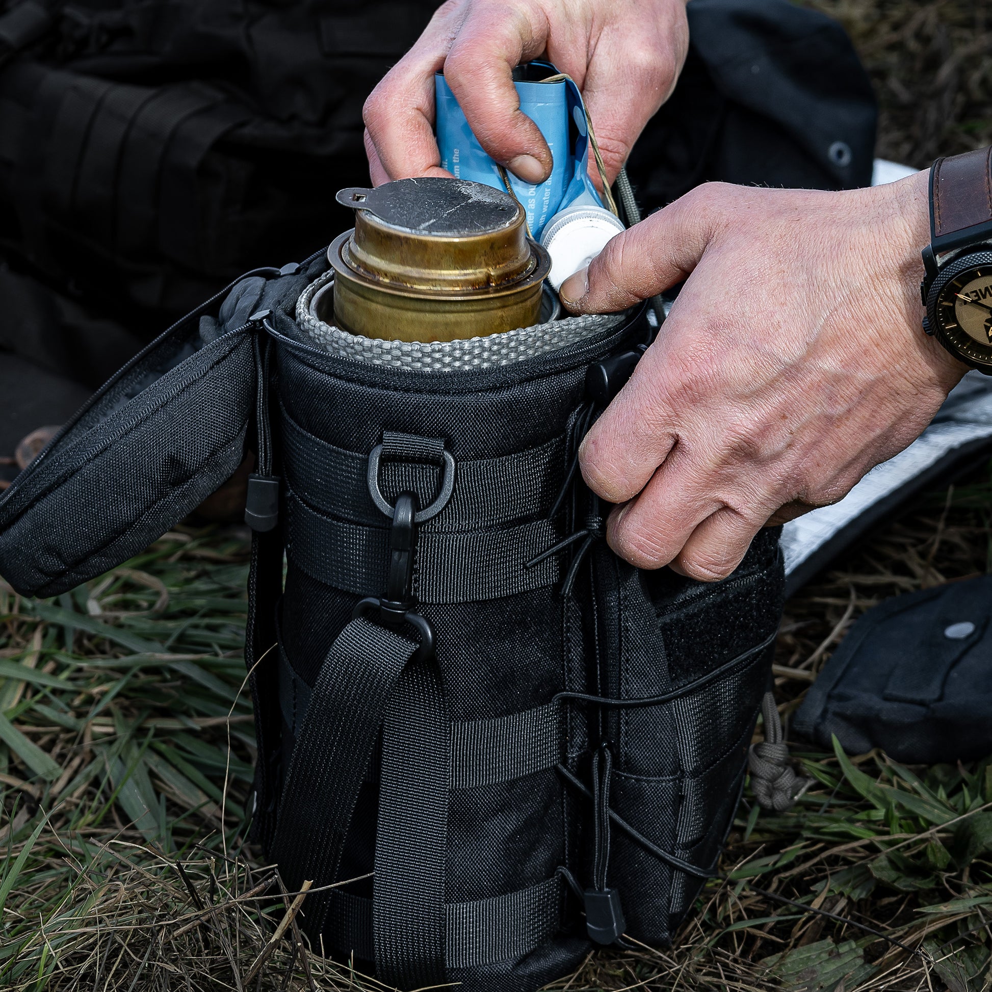 Die Zubehörtasche steht auf einer Wiese und wird bepackt.