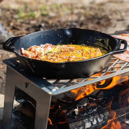 Zubereitung von Rührei mit Speck in einer Pfanne über dem Grillrost 4Fire und einem offenen Lagerfeuer.
