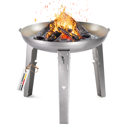 Freisteller der FENNEK Feuerschale Allround. Es lodert ein schönes Feuer im Inneren der Feuerstelle. Das aus Edelstahl gefertigte und sehr hochwertige Feuergestellt überzeugt dank seiner Flexibilität und kann mit Feuerplatte oder Schwenkgrill betrieben werden. Man kann 2 unterschiedliche Höhen für angenehmeres Grillen wählen. Hergestellt in Deutschland.