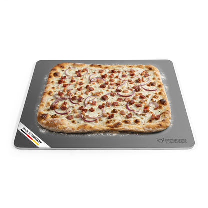 Titelbild vom FENNEK Backstahl mit den Abmessungen 46 x 38 (L x B). Zu sehen ist ein klassischer Flammkuchen, der auf dem Backstahl gebacken wurde. Unten links an der Ecke des Backstahls verdeutlicht eine Banderole, dass der FENNEK Backstahl Made in Germany ist. 