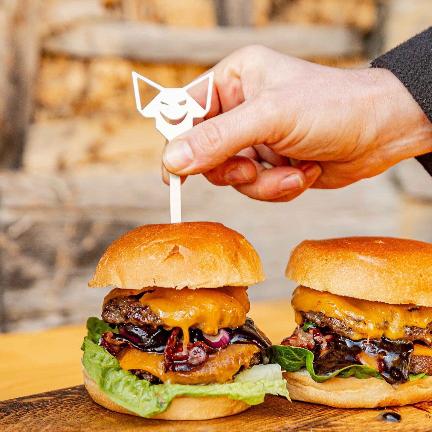 Ein FENNEK Burgerspieß wird in einen Burger gesteckt.