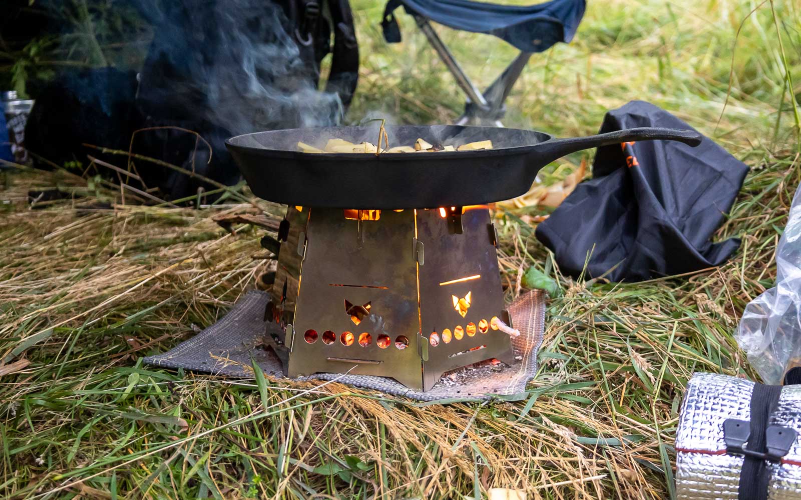 Der FENNEK Hobo mit Erweiterungsset steht auf der FENNEK Flammschutzmatte. Durch die Erweiterung ist dieser für große Pfannen geeignet.