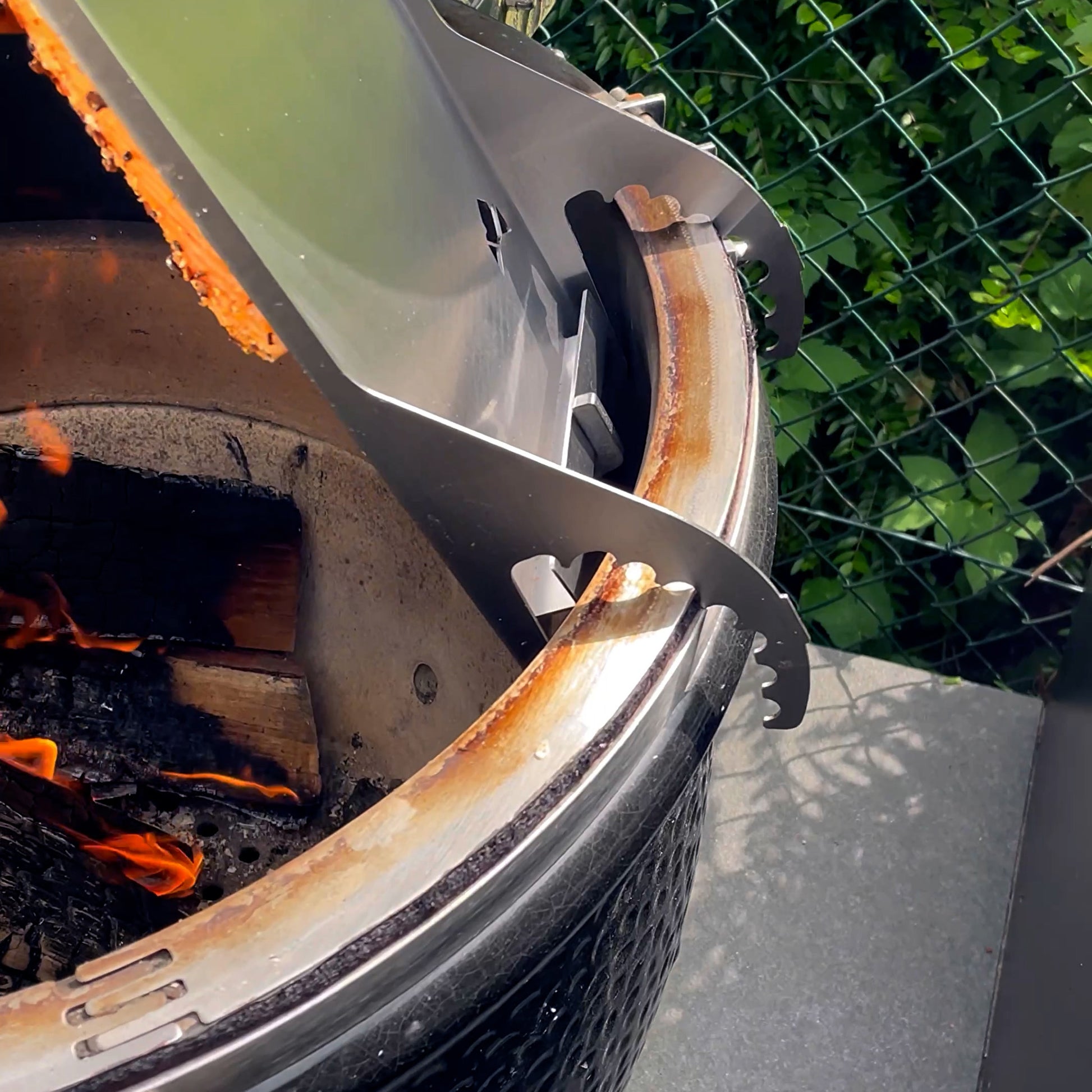 Flammlachsbrett aus Edelstahl Rückenansicht montiert an einem Monolith Grill.