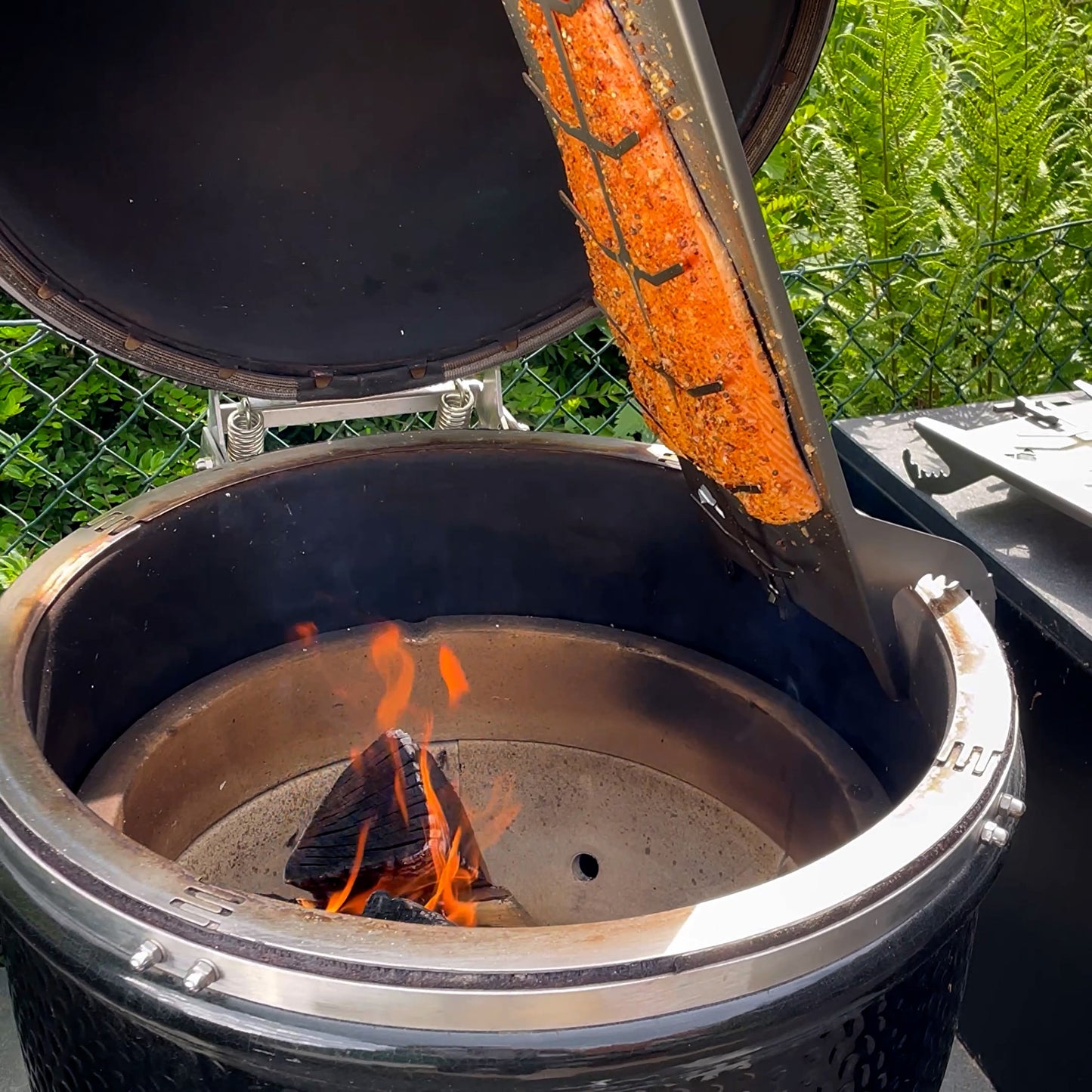 Flammlachsbrett aus Edelstahl montiert an einem Monolith Grill.