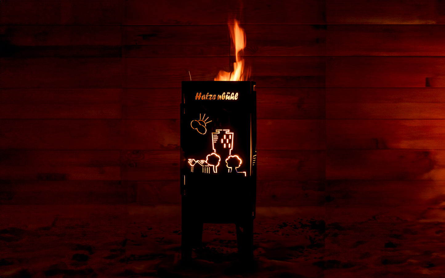 FENNEK Feuersäule Hatzenbühl Edition in Aktion mit schönem loderndem Feuer, das die auf der Feuersäule ausgelaserte Skyline von Hatzenbühl erstrahlen lässt.