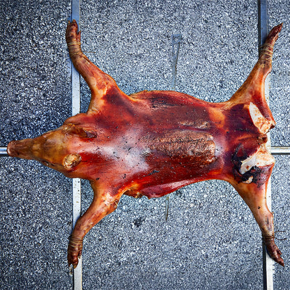 Spanferkel, welches auf den Querstreben befestigt ist.