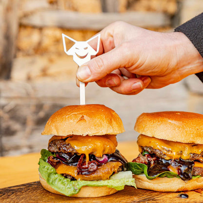Ein FENNEK Burgerspieß wird in einen Burger gesteckt.