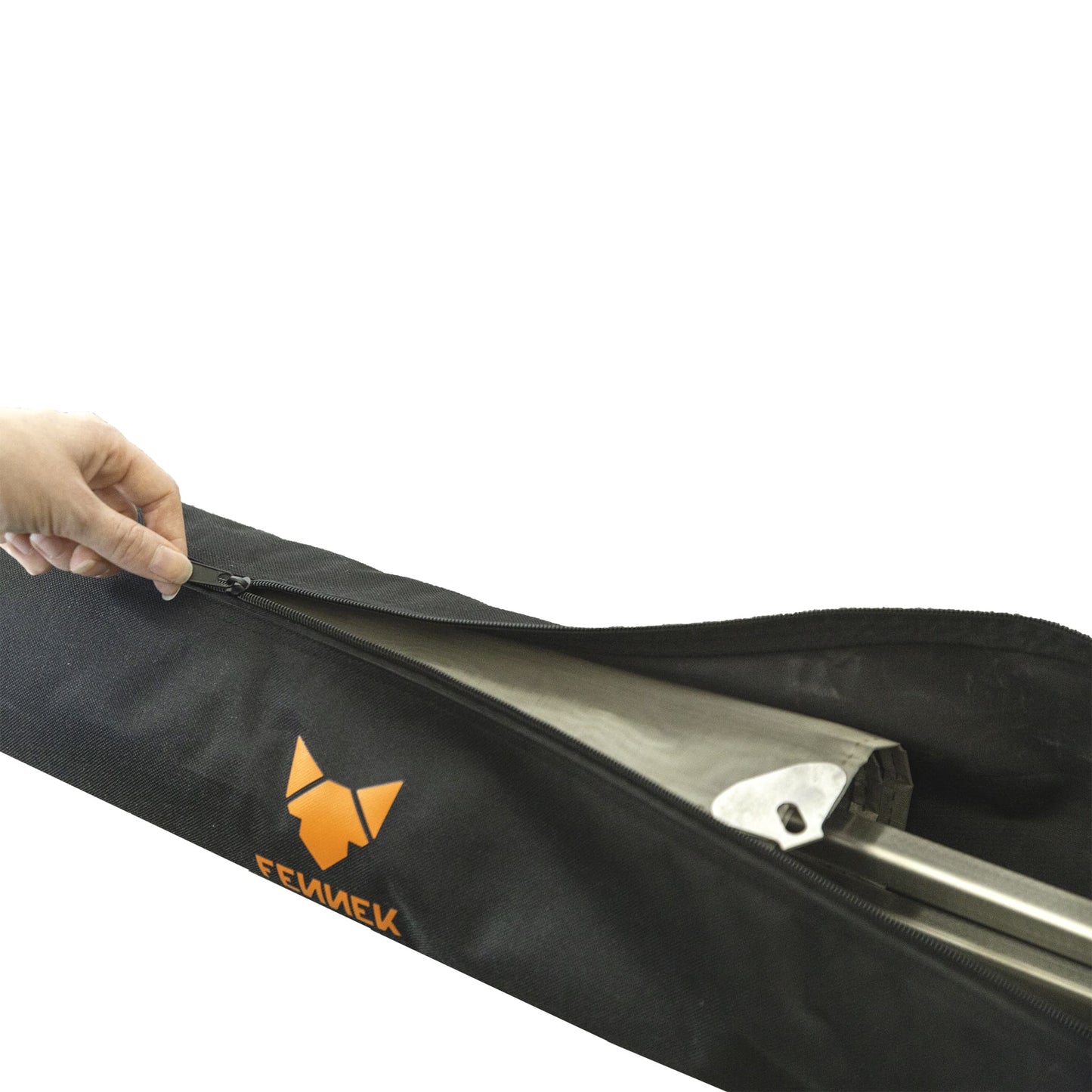 Eine Hand öffnet den Reißverschluss einer schwarzen Nylon-Tasche mit FENNEK Logo-Aufdruck in orange und darin ist das verpackte Feuernetz zu sehen.