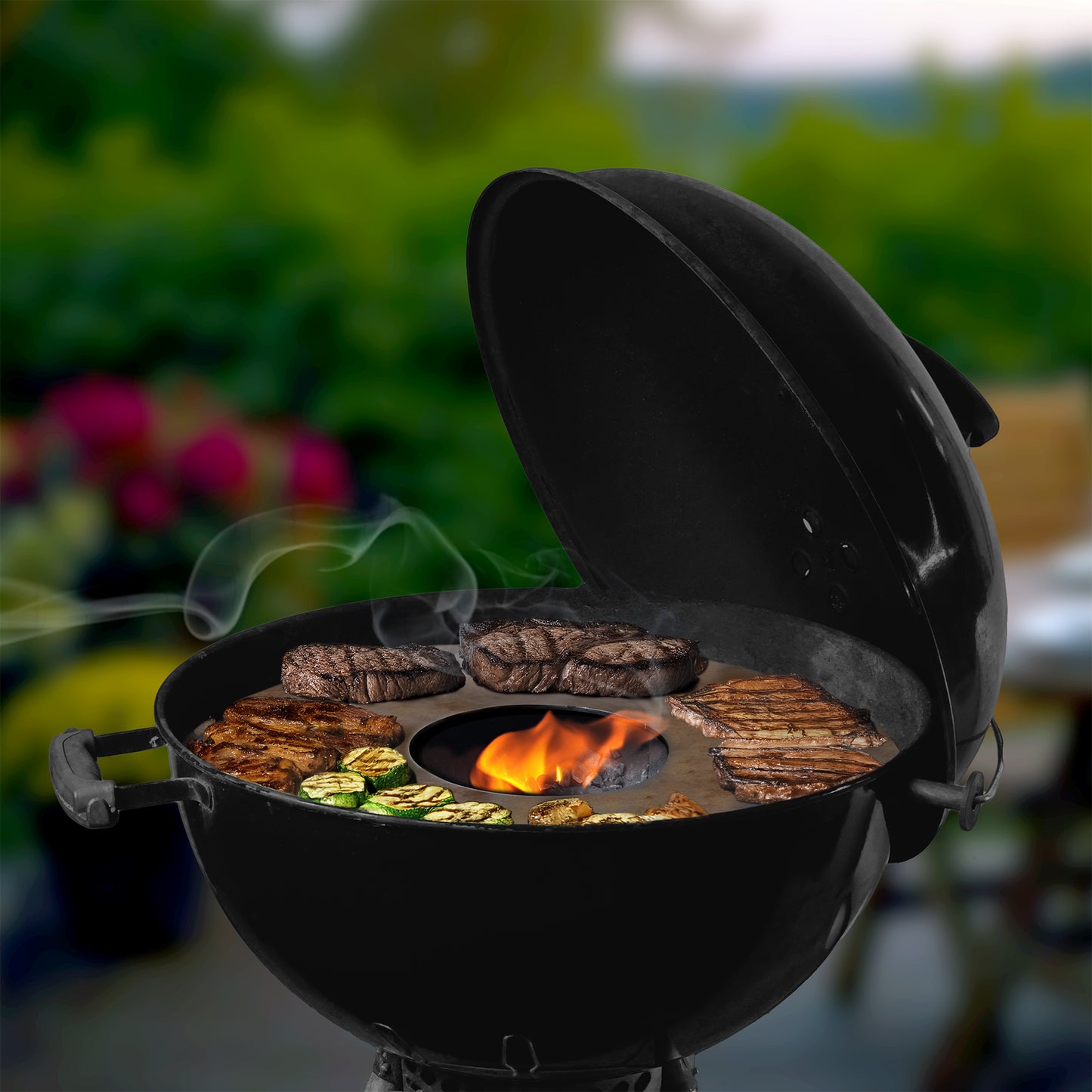 Die FENNEK Feuerplatte 55 cm im Weber Kugelgrill - bestückt mit saftigem Grillgut.