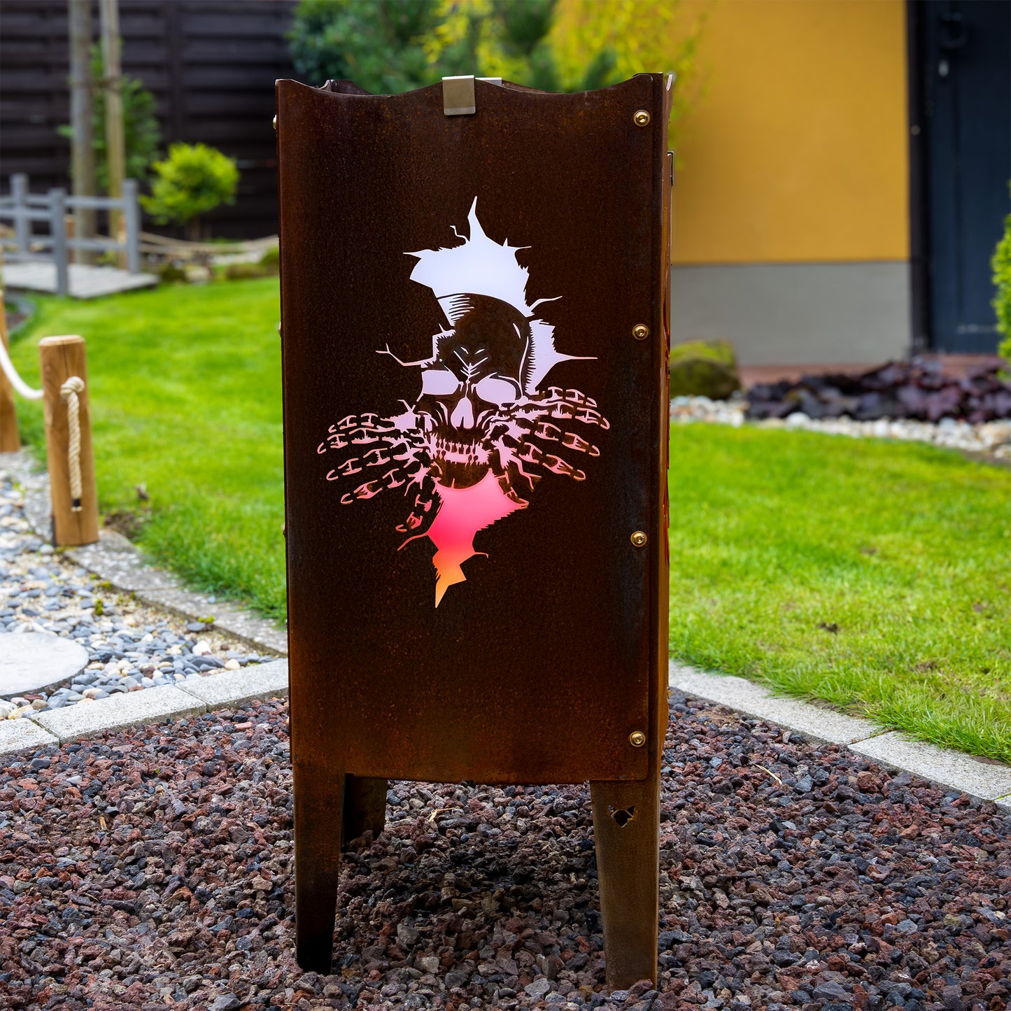 FENNEK Feuersäule mit Motiv - beleuchtet sorgt sie für eine angenehme Atmosphäre. Das Logo - in dem Fall der Totenkopf - kommt bei dieser Feuerstelle sehr gut heraus. Made in Germany aus Stahl oder Edelstahl. Hier die Version aus Stahl in einer schönen Rostoptik.