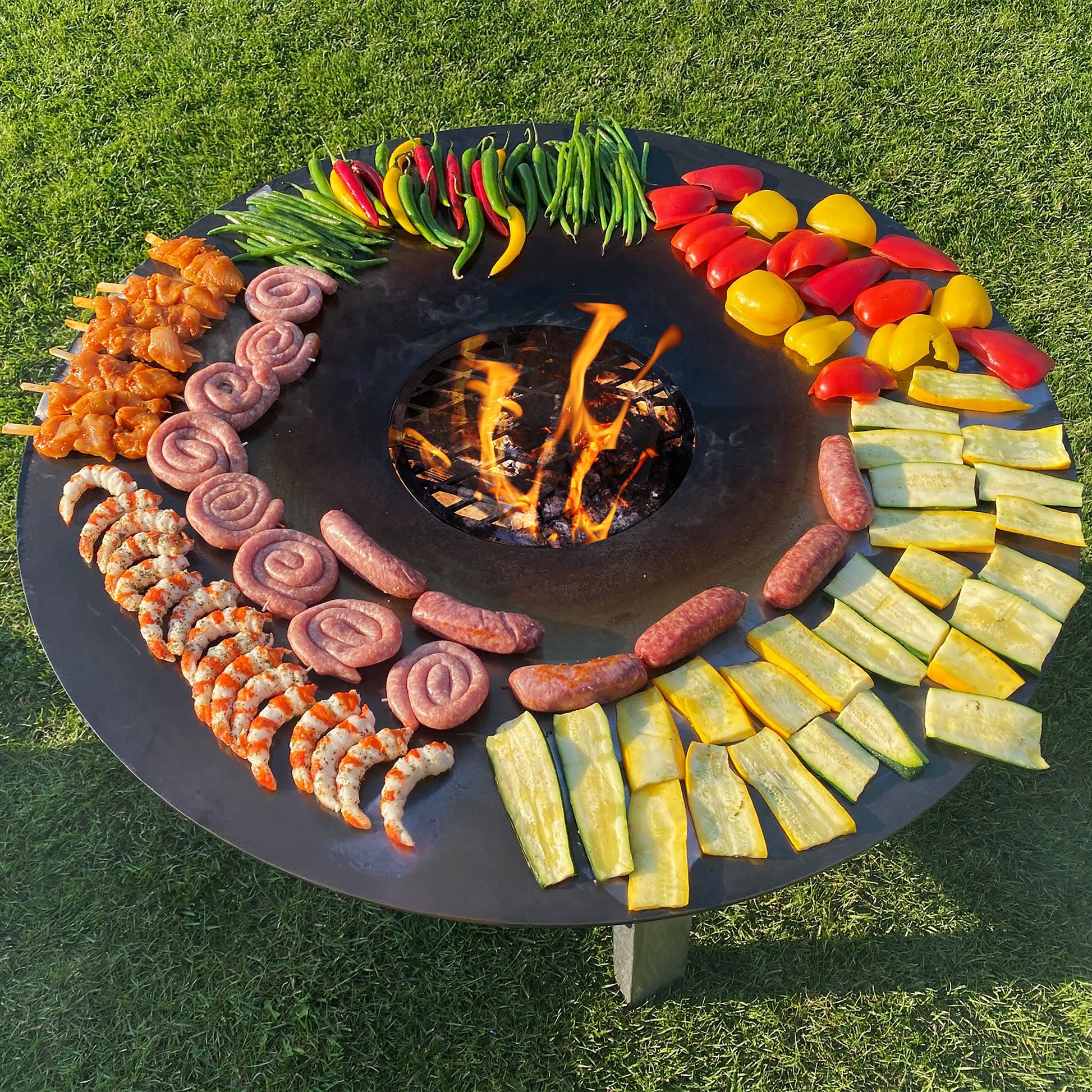 FENNEK Feuerschale Allround mit Feuerplatte und verschiedenem Grillgut darauf