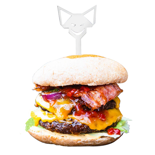 Edelstahl Burgerspieß mit FENNEK-Kopf-Griff steckt im saftigen, Doppel-Cheeseburger mit gebratenem Bacon und Salat, vor weißem Hintergrund