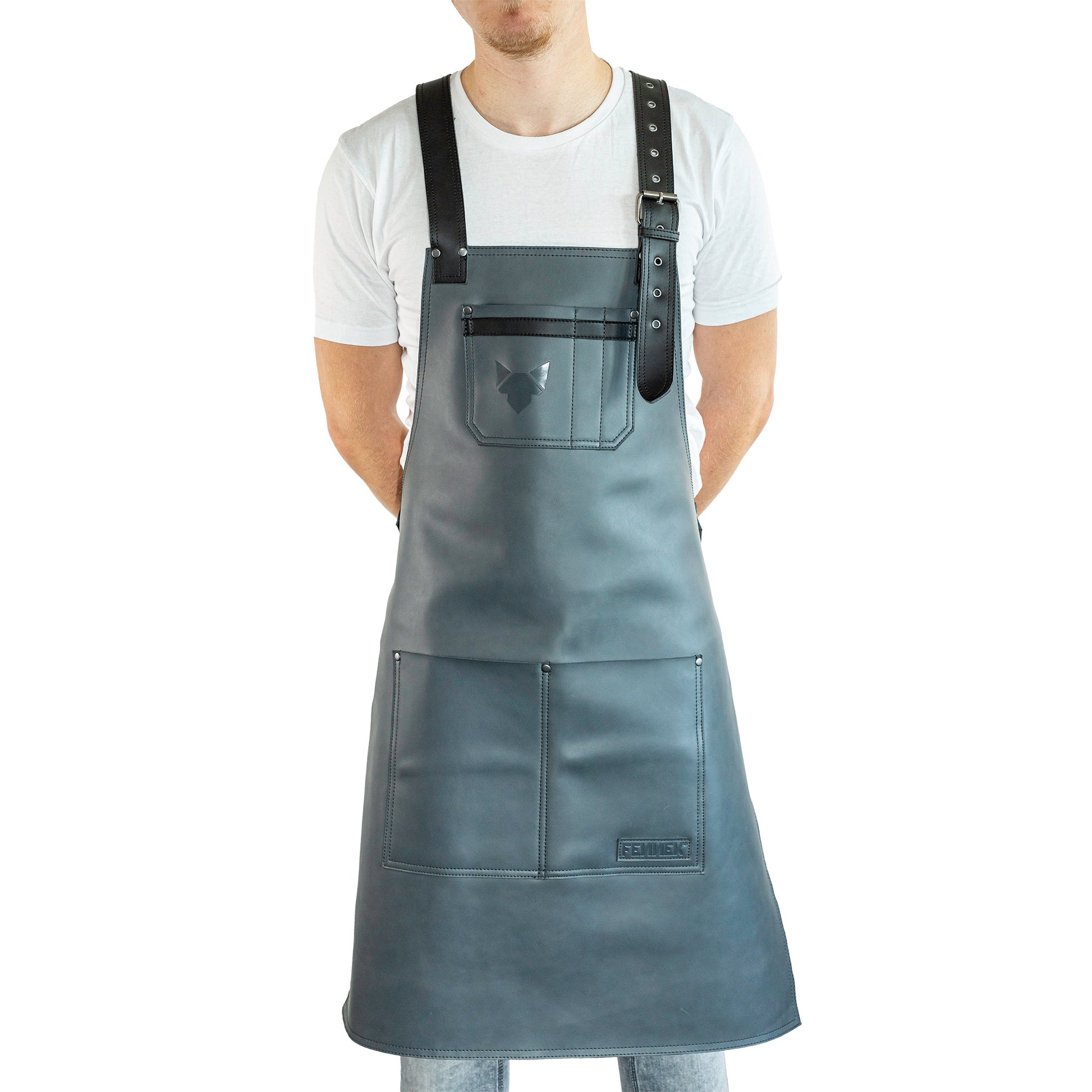 Brustbereich Leder-Grillschürze mit geprägtem FENNEK-Logo und mit verstellbarem Lederriemen, Schnalle und aufgesetzten Taschen, getragen von einem Mann