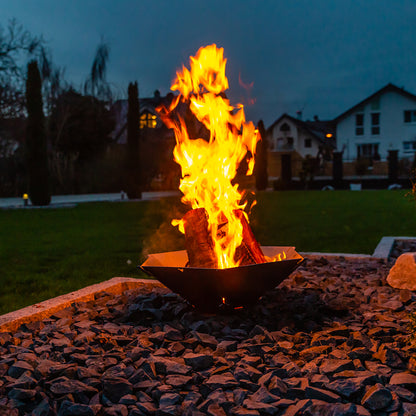 Brennendes Feuer in der Feuerschale Hexagon bei Dunkelheit im Garten..