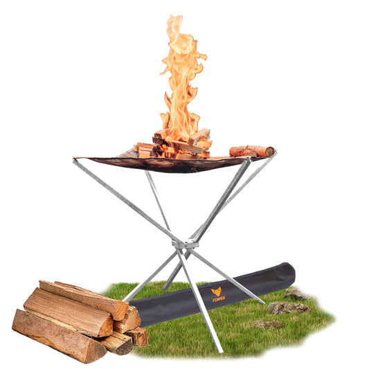 Das FENNEK Feuernetz High Fire, eine ungewöhnliche Feuerschale, steht auf einem kleinen Stückchen grünem Rasen. Auf dem Rasen liegt der Köcher, in dem das High Fire geliefert wird. Ebenso ein Stapel Holzscheite. Das High Fire ist gerade in Betrieb, eine schöne Flamme ist zu sehen.