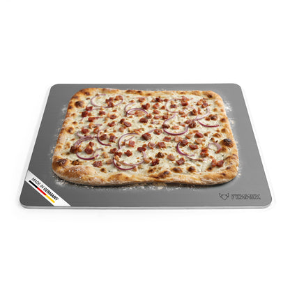 Titelbild vom FENNEK Backstahl mit den Abmessungen 46 x 38 (L x B). Zu sehen ist ein klassischer Flammkuchen, der auf dem Backstahl gebacken wurde. Unten links an der Ecke des Backstahls verdeutlicht eine Banderole, dass der FENNEK Backstahl Made in Germany ist. 