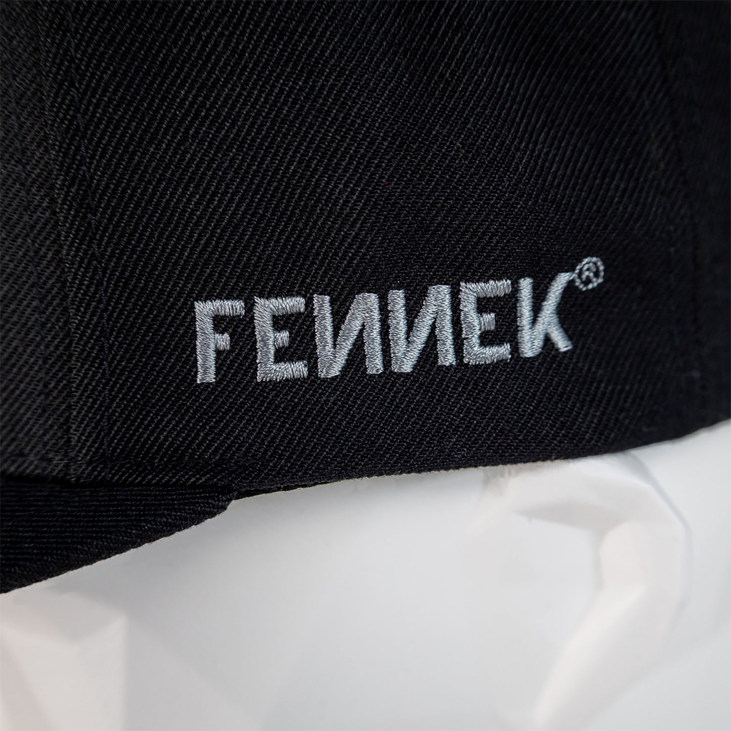 Detailaufnahme vom aufgestickten FENNEK Schriftzug.