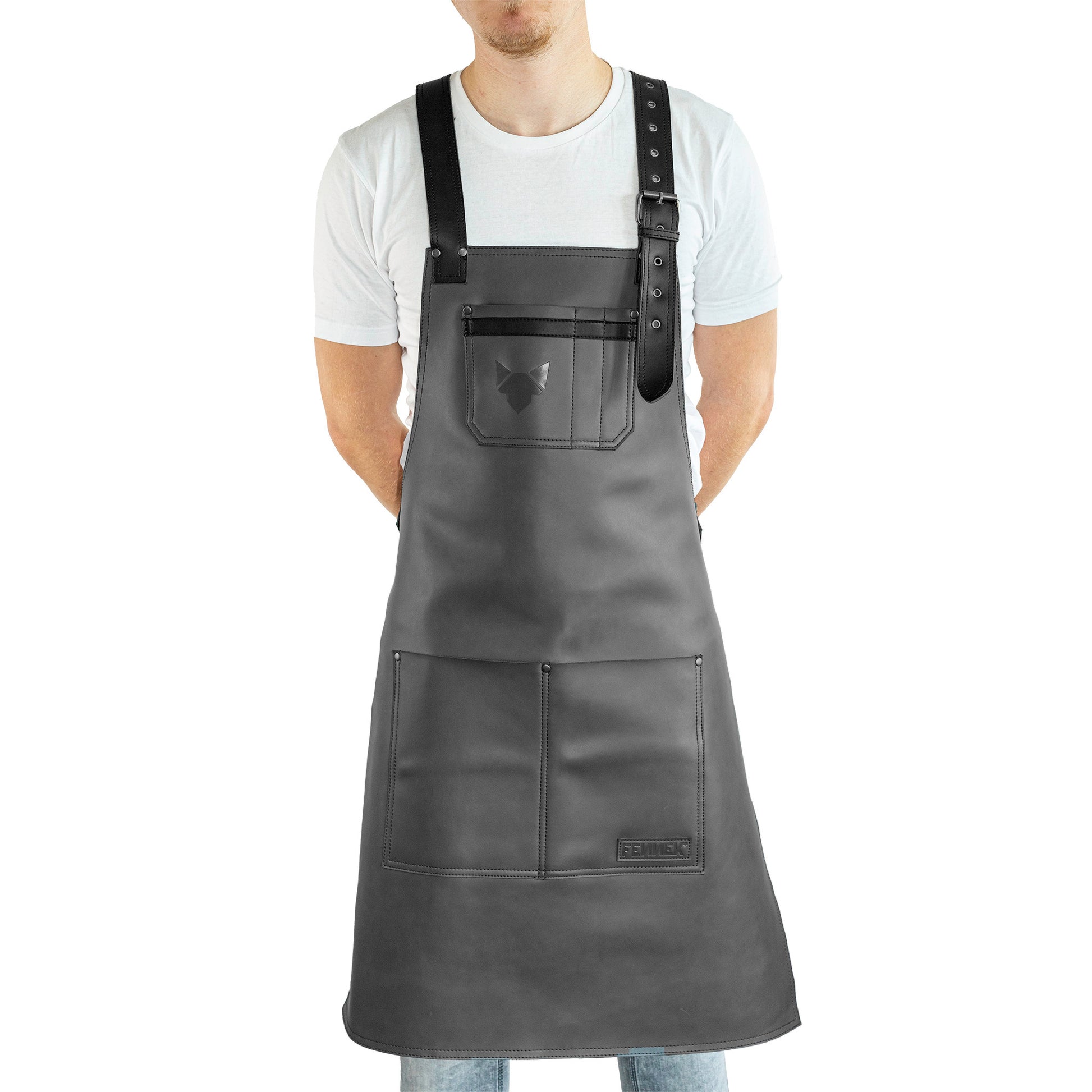 Brustbereich Leder-Grillschürze mit geprägtem FENNEK-Logo und mit verstellbarem Lederriemen, Schnalle und aufgesetzten Taschen, getragen von einem Mann
