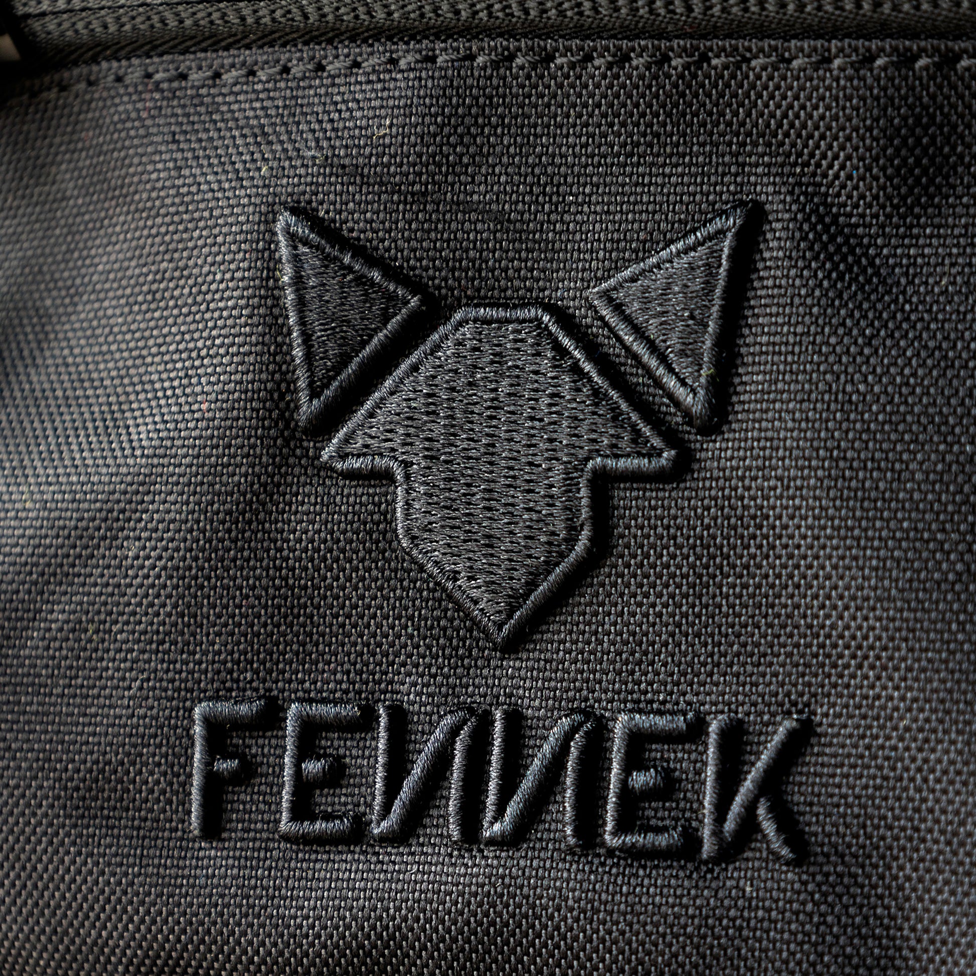 Nahe Sicht auf das hochwertig gestickte Logo FENNEK beim Backpack One2explore.