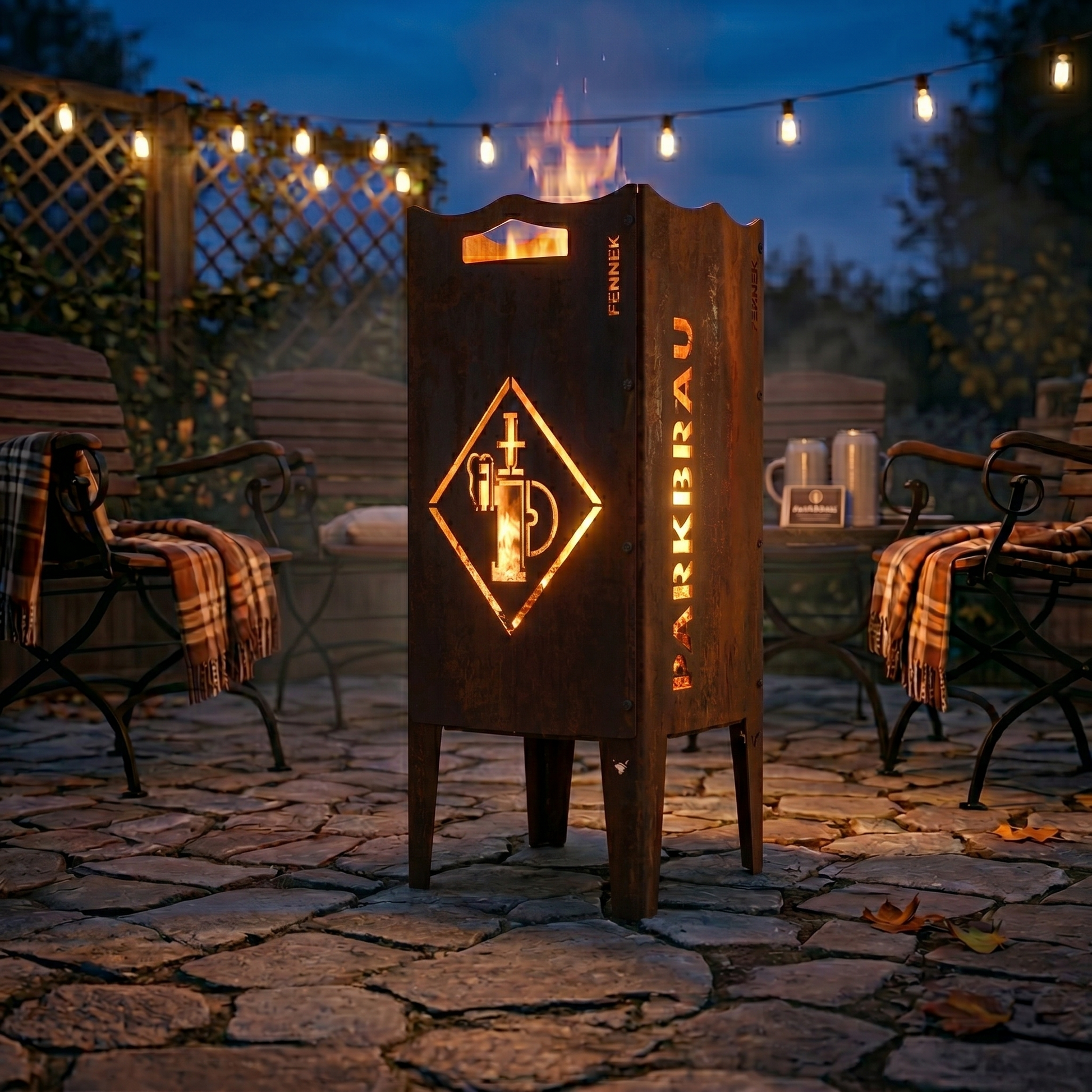 Die FENNEK Feuersäule mit dem Parkbräu Logo steht auf der Terrasse bei schönem abendlichen Licht. Ein warmes Feuer lodert und sorgt für eine gemütliche Stimmung. Die Säule aus Stahl hat eine schöne Rostoptik und eignet sich somit perfekt als rustikaler Eyecatcher.