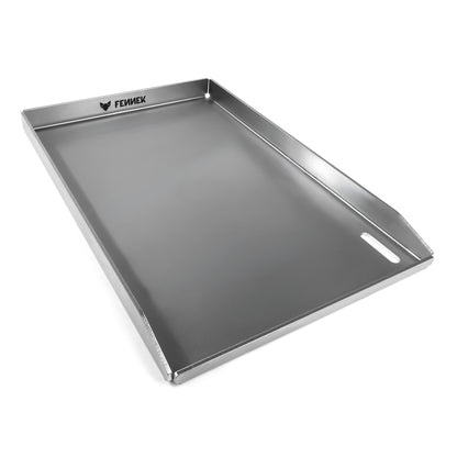 Freisteller der FENNEK Plancha 45 x 30 x 3,5 cm. Sie hat eine hochgezogene Vorderkante, damit kein Grillgut herunterfallen kann. Zusätzlich hat sie vorne rechts in der Ecke ein großzügiges Ablaufloch, worüber überschüssiges Fett und Grillreste in die Fettauffangwanne entsorgt werden können. Die vier Ecken sind offen, damit hier auch das überschüssige Fett abgeleitet werden kann. Ein Hingucker ist der eingravierte FENNEK Schriftzug.