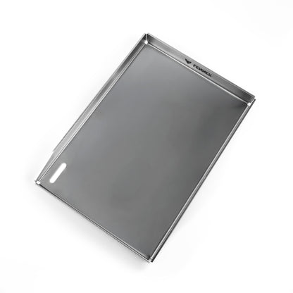 Freisteller der FENNEK Plancha 43 x 30 x 4 cm. Sie hat eine hochgezogene Vorderkante, damit kein Grillgut herunterfallen kann. Zusätzlich hat sie vorne links in der Ecke ein großzügiges Ablaufloch, worüber überschüssiges Fett und Grillreste in die Fettauffangwanne entsorgt werden können. Die vier Ecken sind offen, damit hier auch das überschüssige Fett abgeleitet werden kann. Ein Hingucker ist der eingravierte FENNEK Schriftzug. Mit ihren Maßen passt die Plancha perfekt zum Enders Boston Pro 4. 