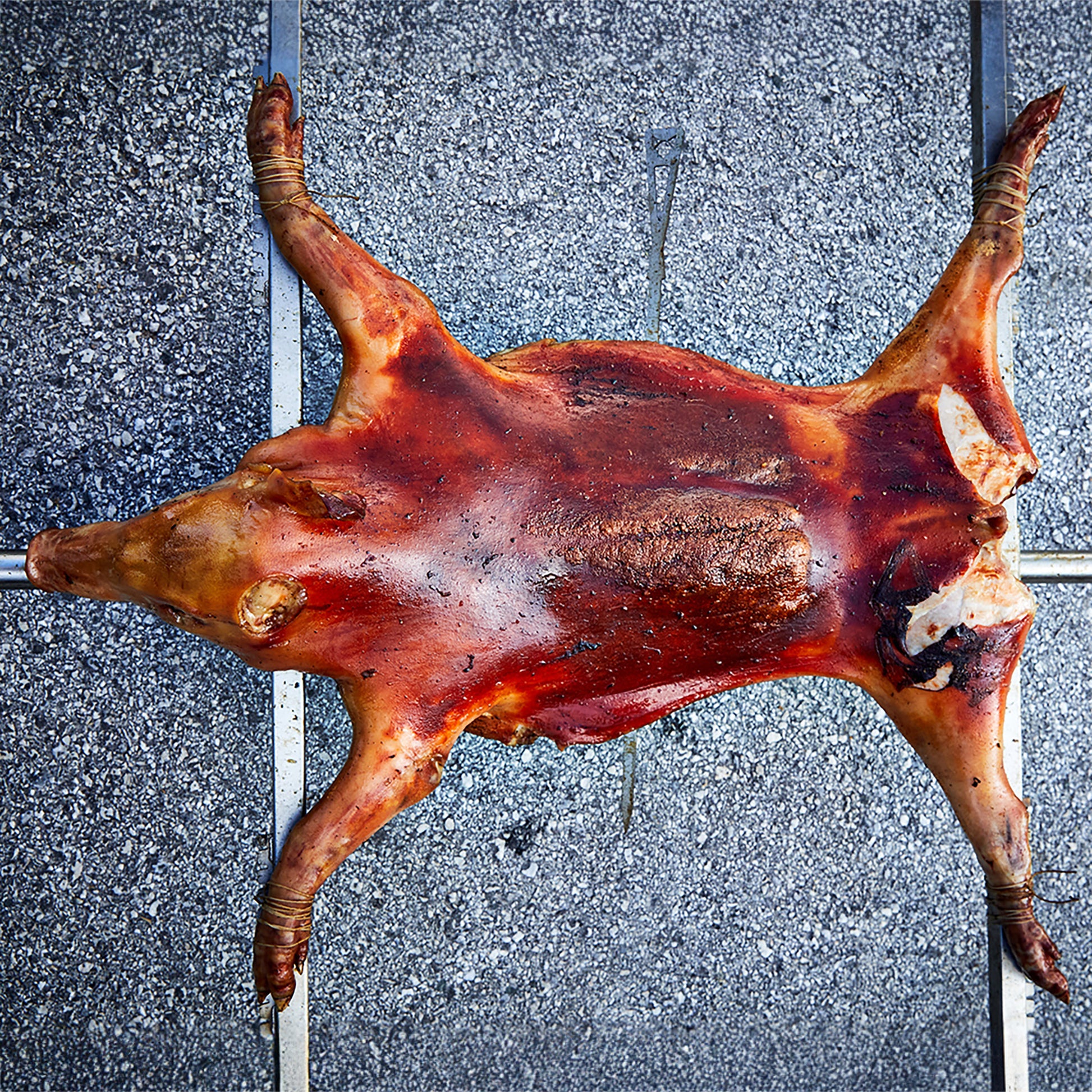 Spanferkel, welches auf den Querstreben befestigt ist.