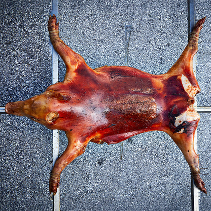 Spanferkel, welches auf den Querstreben befestigt ist.