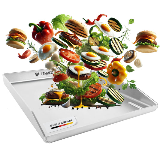 Die FENNEK Plancha 30 x 40 cm als Freisteller. Auf ihr sind schwebend Burger, Spiegelei, frisches Grillgemüse und Salat zu sehen. Made in Germay