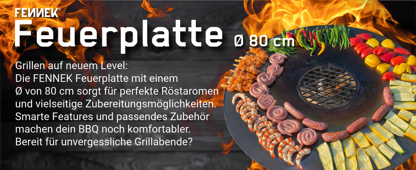 Bild zeigt die FENNEK Feuerplatte in 80 cm im Einsatz, auf ihr grillen Würstchen, Spieße und Gemüse. Das Bild verdeutlicht den vielseitigen Einsatz.