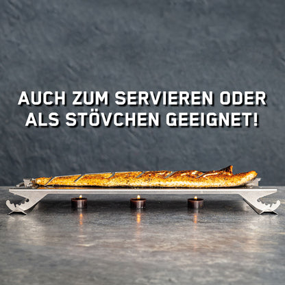 Fertig zubereiteter Flammlachs auf dem Flammlachsbrett aus Edelstahl und darunter 3 Teelichter zum Warmhalten.