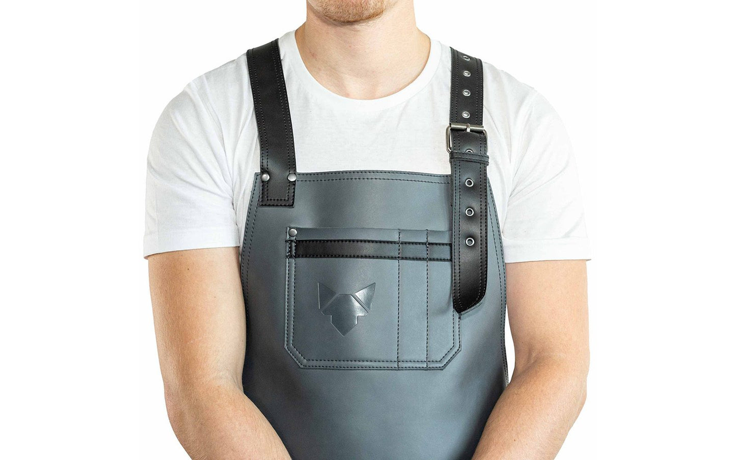 Brustbereich Leder-Grillschürze mit geprägtem FENNEK-Logo und mit verstellbarem Lederriemen, Schnalle und aufgesetzten Taschen, getragen von einem Mann