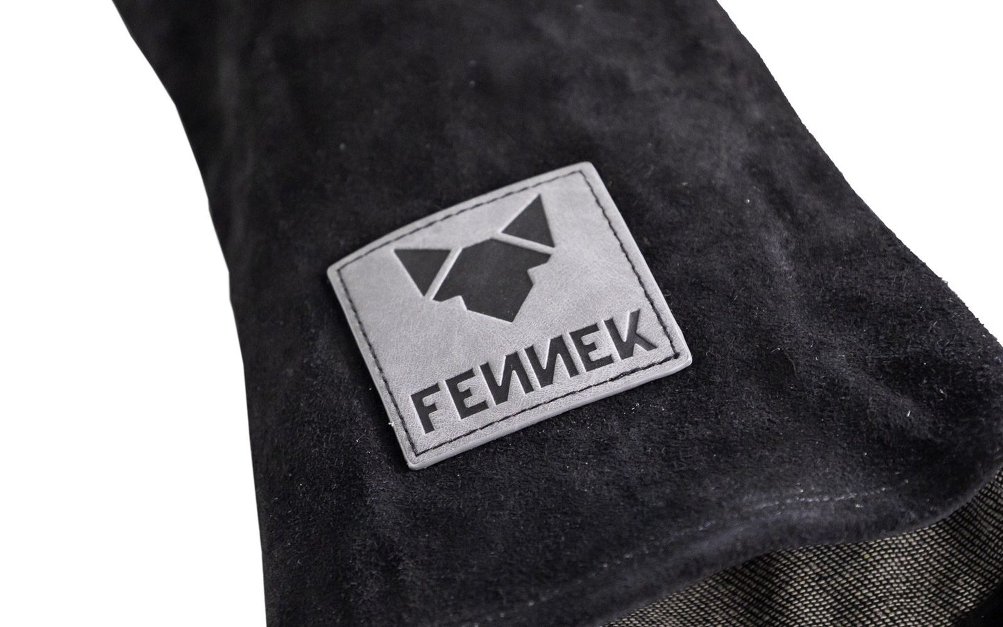 Nahaufnahme der FENNEK-Logo Applikation auf dem schwarzen Leder Grillhandschuh