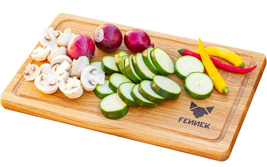 Pilze und anderes buntes Gemüse teilweise geschnitten auf einem hellen Holzbrett mit FENNEK Logo-Branding rechts unten